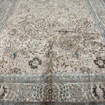 Tabriz-style rug, cream tone with teal-blue border stripes and ornate floral layout.