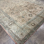 Persian-style Tabriz rug with cream field, blue corner medallions, and patterned border
