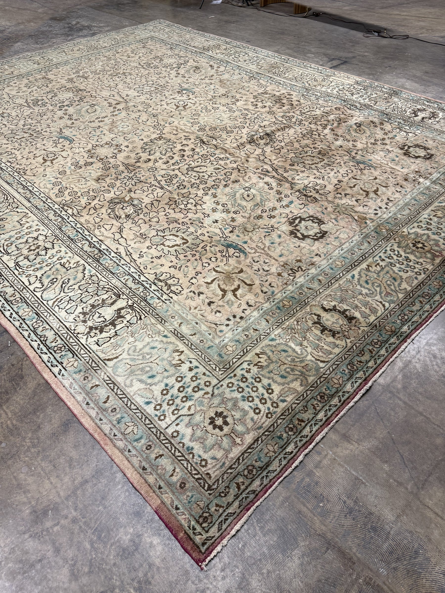 Persian-style Tabriz rug with cream field, blue corner medallions, and patterned border