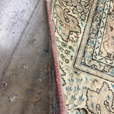 Rug edge detail with cream field, teal outlines, and red binding along the side