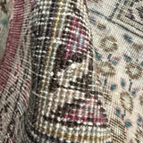 Close-up of rug fringe and textured weave with black, gold, and muted red accents