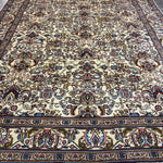 Tabriz-style rug, cream field with navy, red and blue floral medallions, wide border