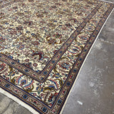 Tabriz rug corner with red and blue floral motifs, dark navy border stripe, fringe