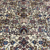 Tabriz rug close-up: cream background with red, blue, green floral scrollwork
