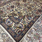 Tabriz rug folded corner showing ornate vase and floral pattern, multicolor border, fringe