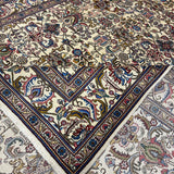 Tabriz rug folded corner showing ornate vase and floral pattern, multicolor border, fringe
