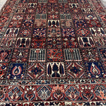 Bakhtiari Persian rug wide view with red, navy, cream and repeating niche motifs