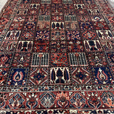 Bakhtiari Persian rug wide view with red, navy, cream and repeating niche motifs