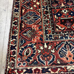 Bakhtiari Persian rug close-up of red field with navy cream medallions and border