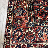Bakhtiari Persian rug close-up of red field with navy cream medallions and border