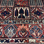 Bakhtiari Persian rug close-up with red and navy panels, cream accents, and fringe
