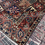 Bakhtiari Persian rug diagonal pattern close-up with red, navy, cream and small motifs