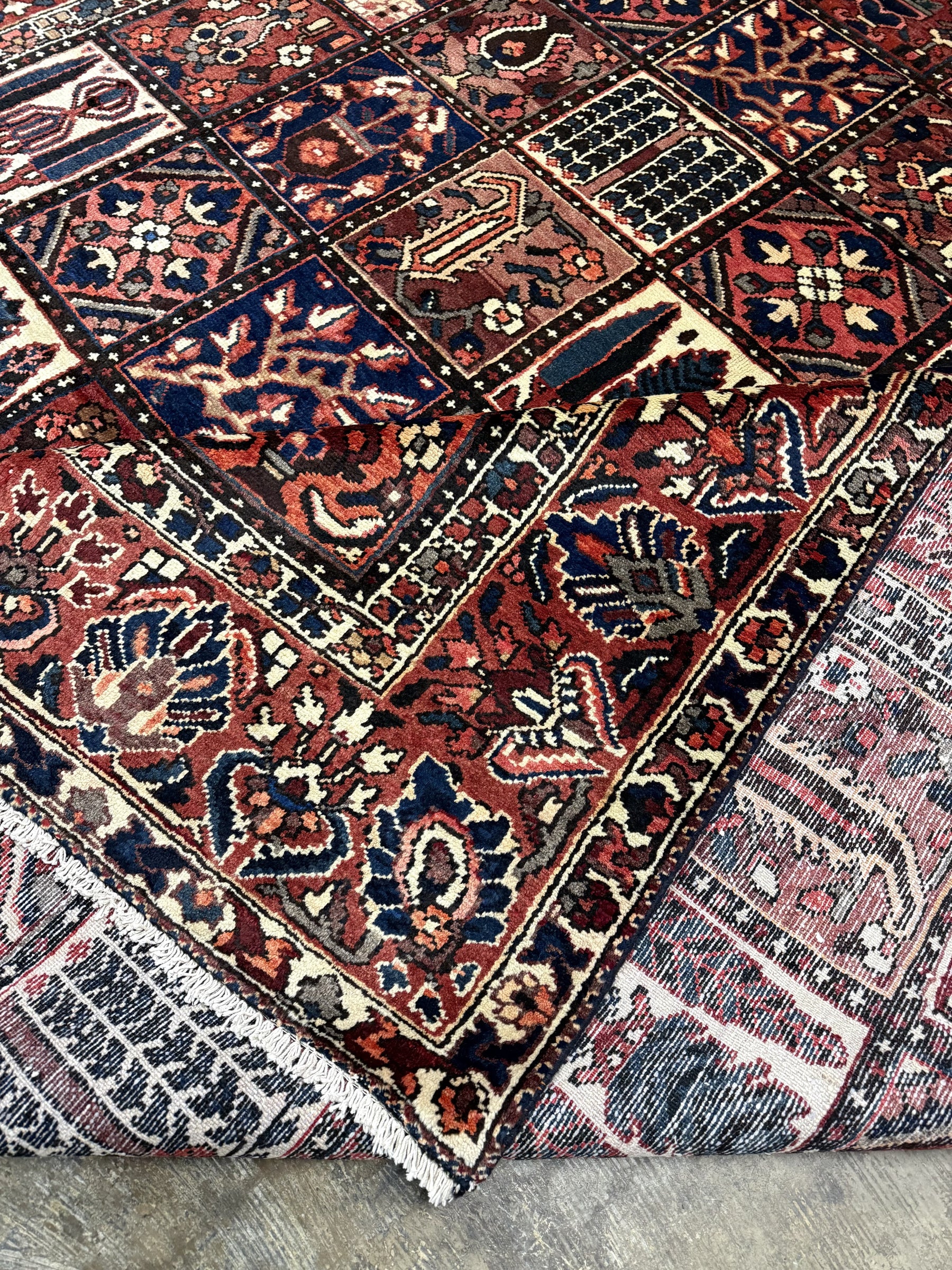 Bakhtiari Persian rug diagonal pattern close-up with red, navy, cream and small motifs
