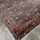 Persian-style rug with geometric medallion pattern, navy, rust, and cream, fringed ends