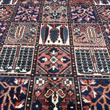 Geometric Persian rug panel design in navy, rust, and cream, closely detailed motifs