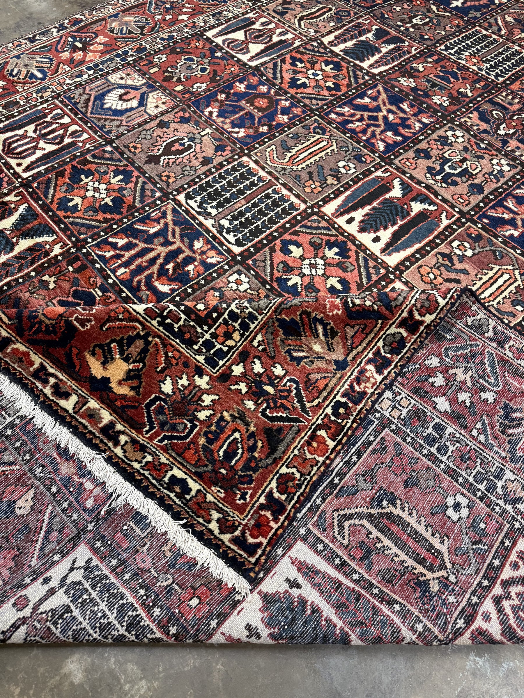Multicolor geometric rug with navy, rust, cream and maroon blocks, fringed selvage edge