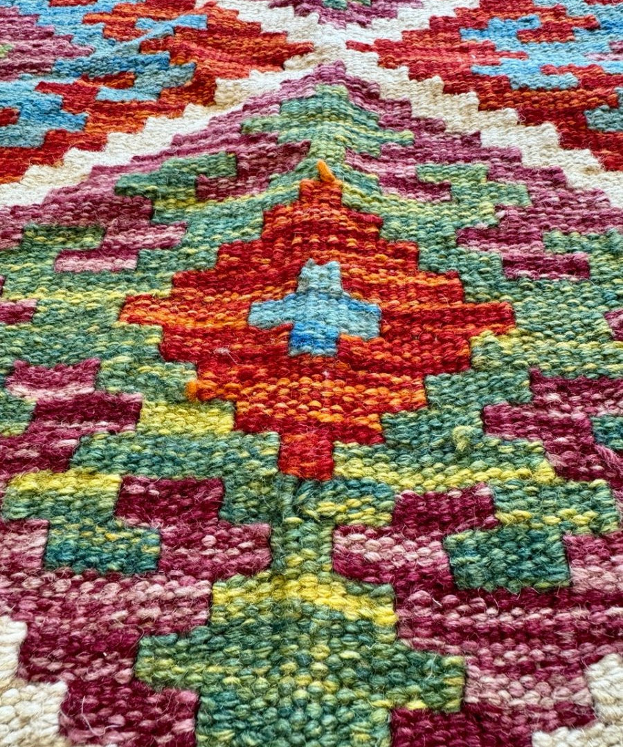 Afghan Chobi kilim rug close-up of multicolor floral medallion on textured field