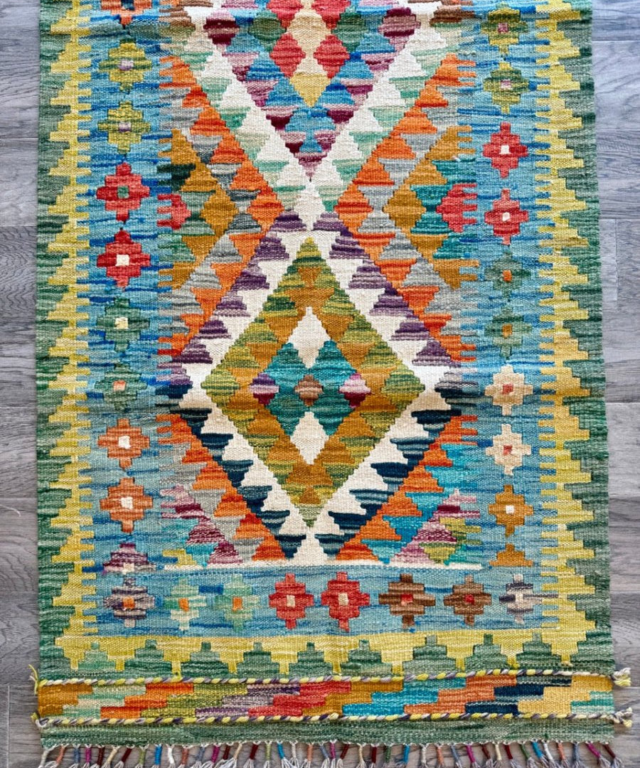 Woven kilim runner rug with multicolor diamond and stepped geometric pattern, flat weave.