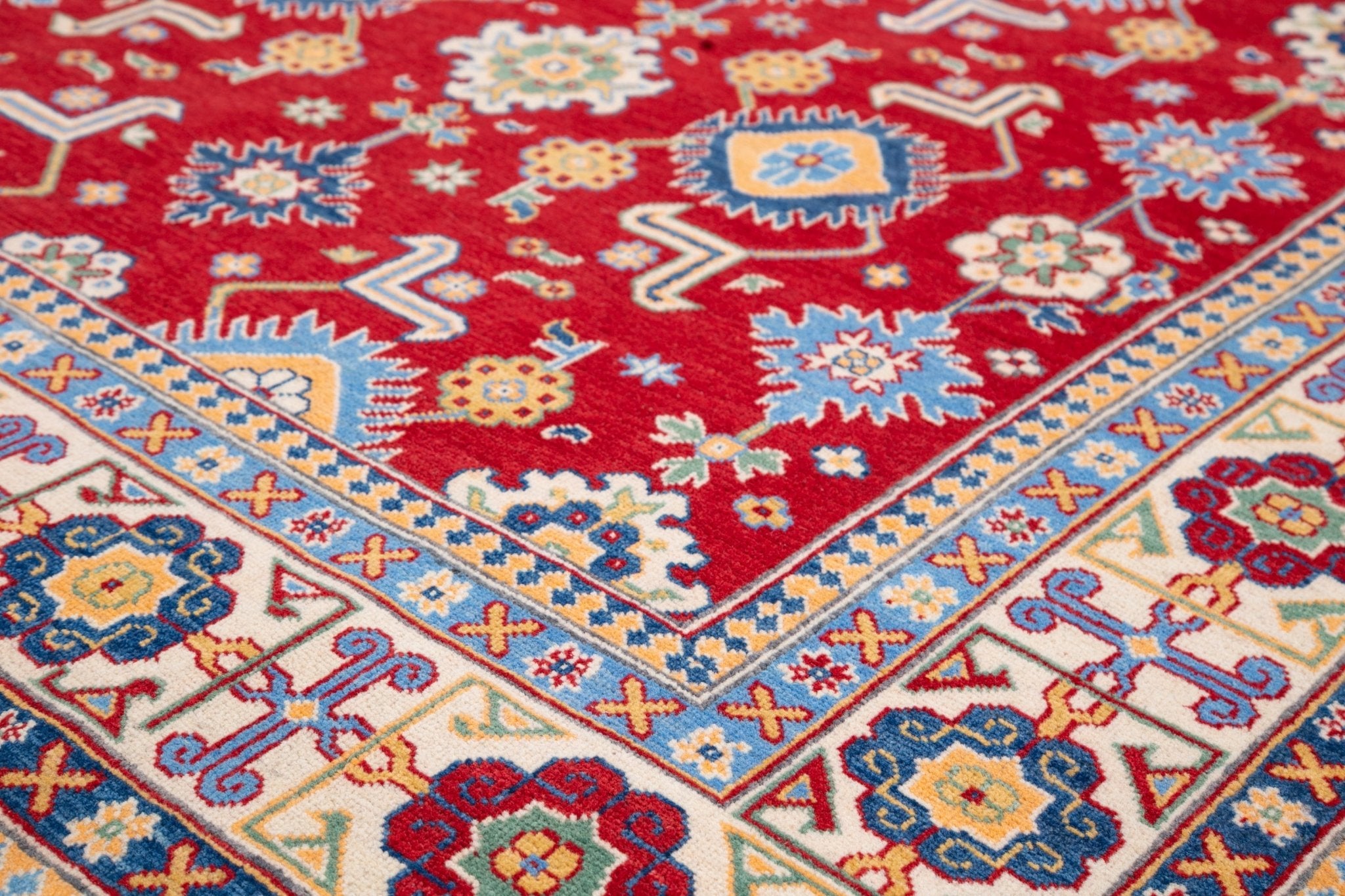 Folded edge and wool pile of red & blue Kazak-inspired wool rug 21542.