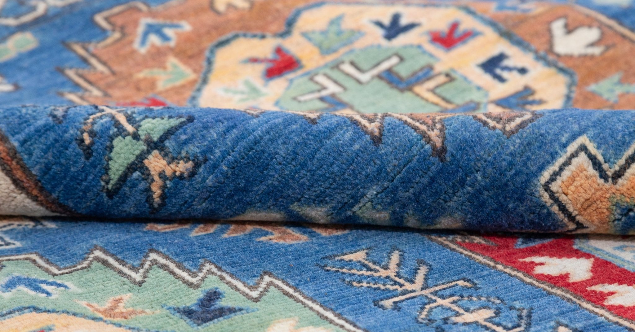 Folded edge and wool pile of blue & red Kazak-inspired wool rug 29635.
