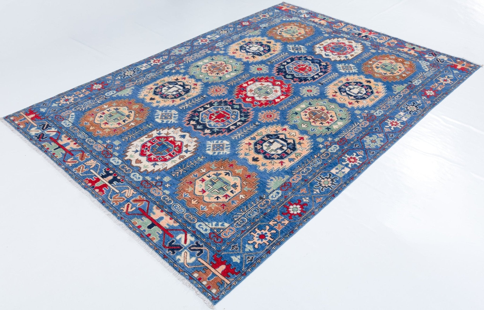 Full view at an angle of blue & red Kazak-inspired wool rug 29635.