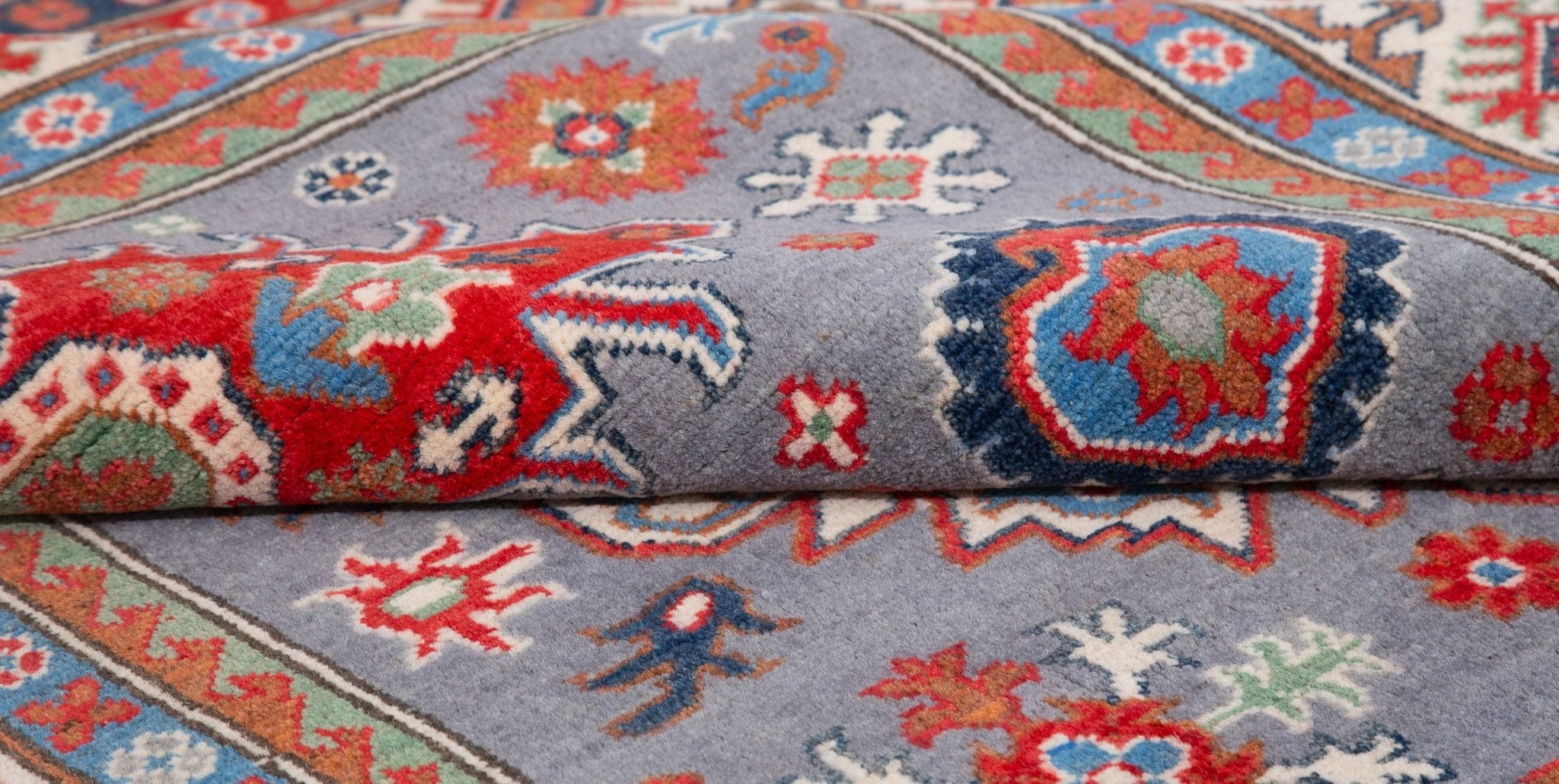 Folded edge and wool pile of blue & red Kazak-inspired wool rug 29345.