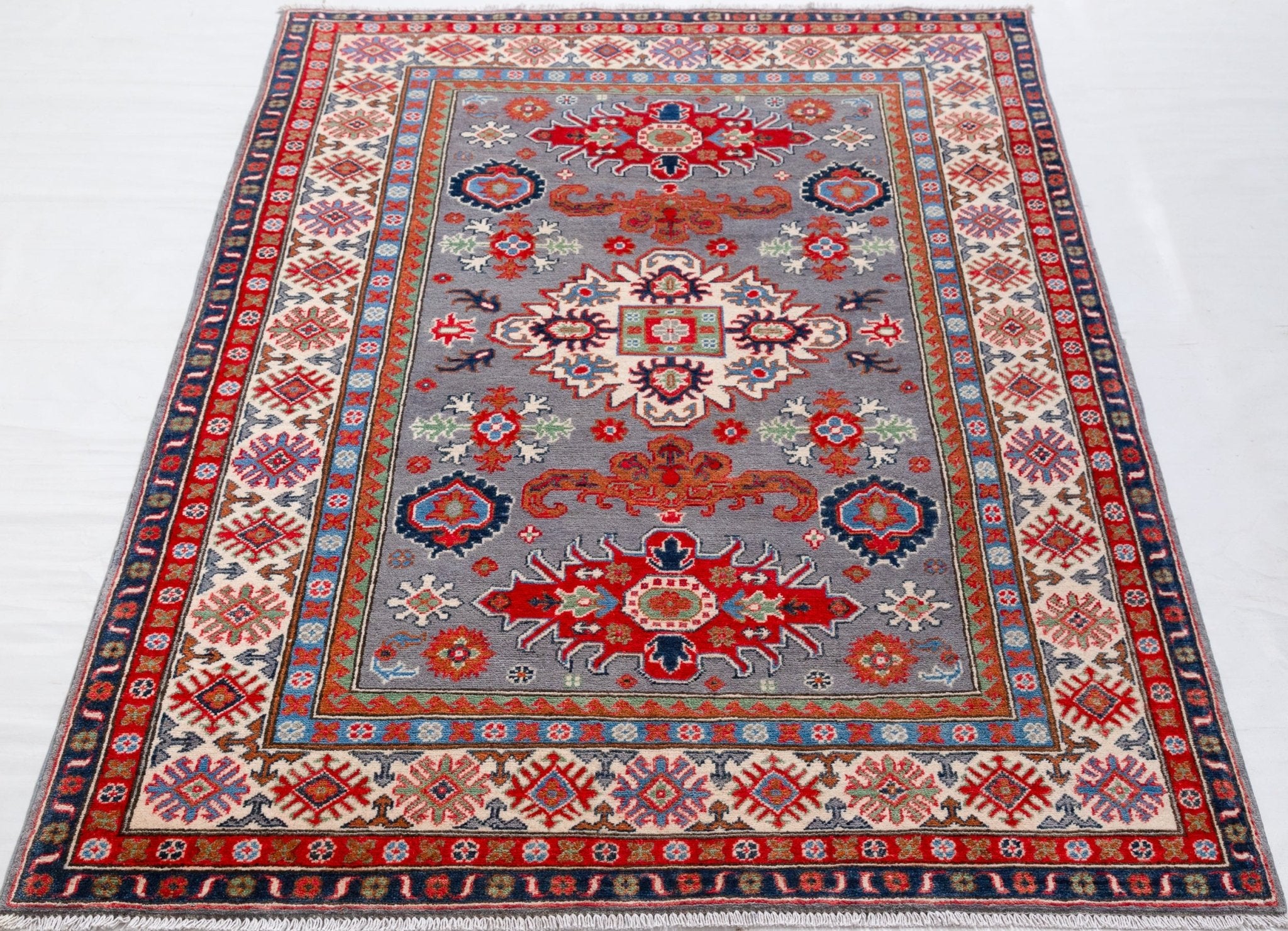 Full view from a low angle of blue & red Kazak-inspired wool rug 29345.