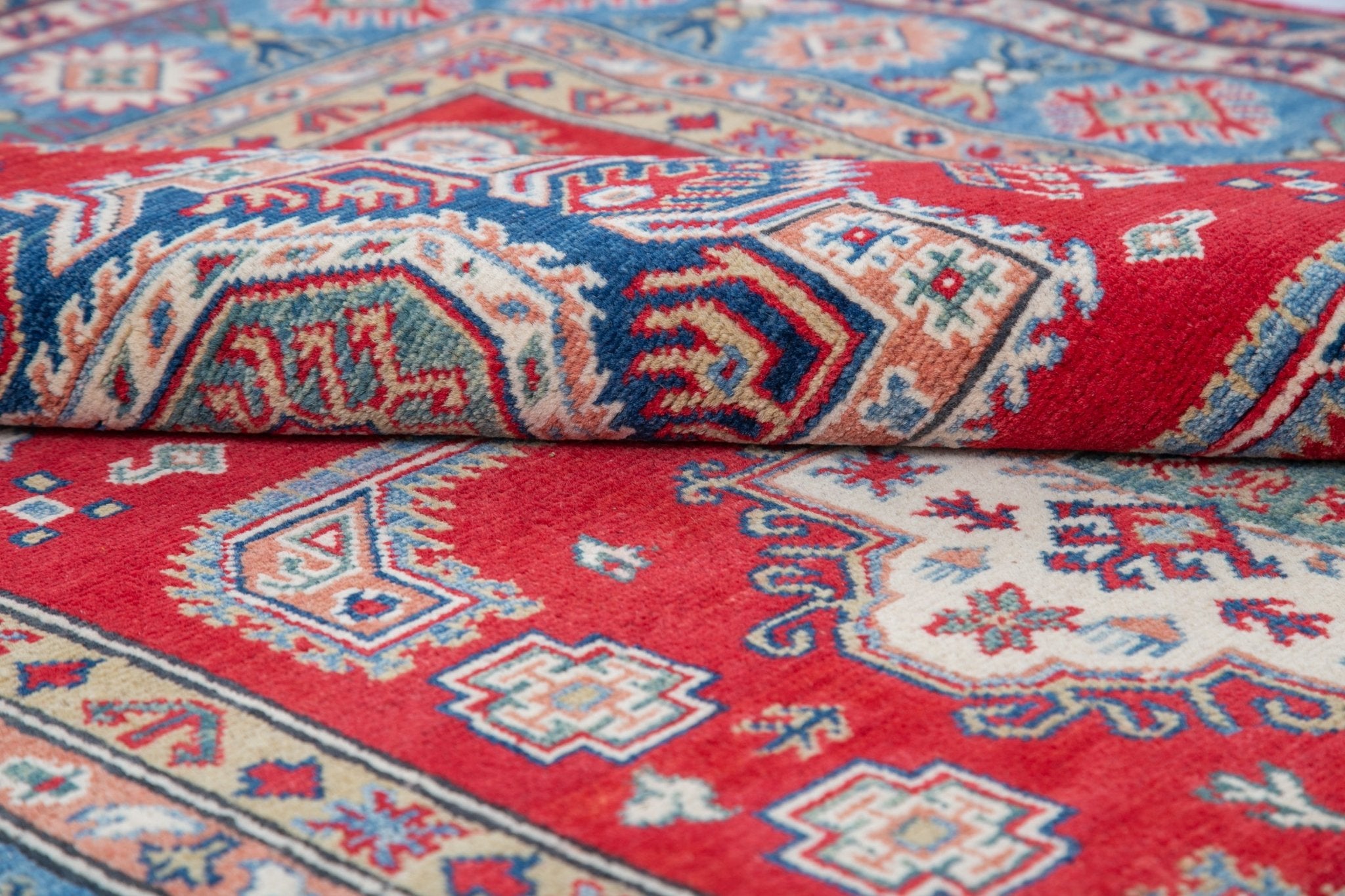 Folded edge and wool pile of red & blue Kazak-inspired wool rug 21613.