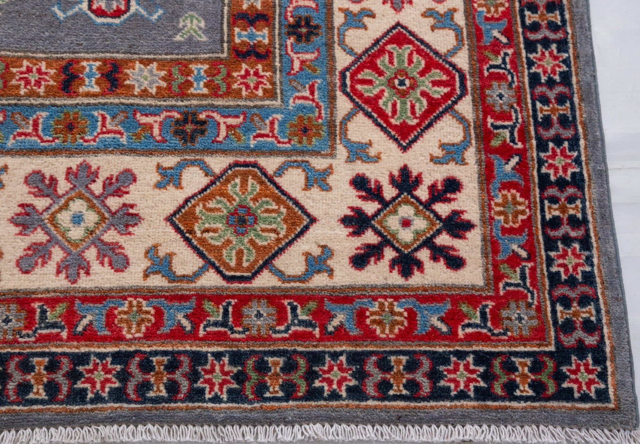 Border and edge detail of blue & red Kazak-inspired wool rug 29339.