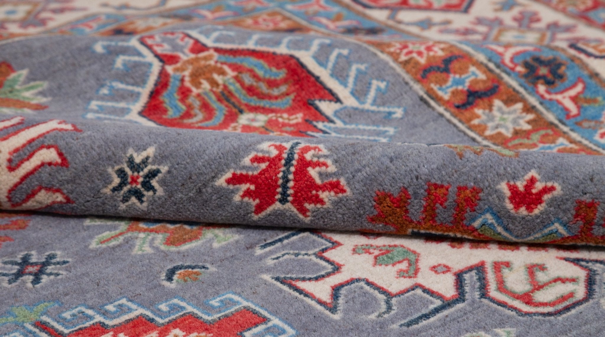 Folded edge and wool pile of blue & red Kazak-inspired wool rug 29339.