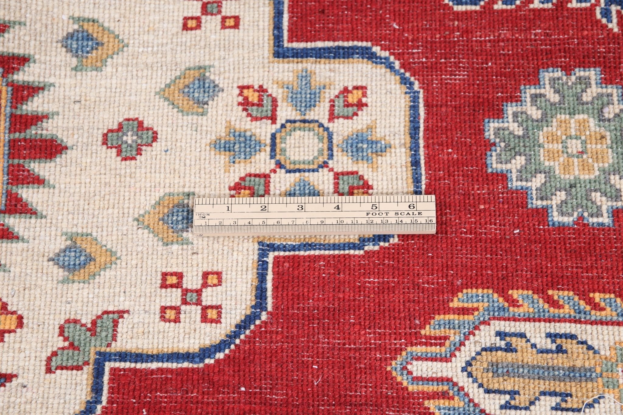 Folded edge and wool pile of red & ivory Kazak-inspired wool rug 22082.