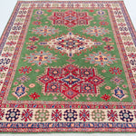 Full view from a low angle of green & red Kazak-inspired wool rug 29641.