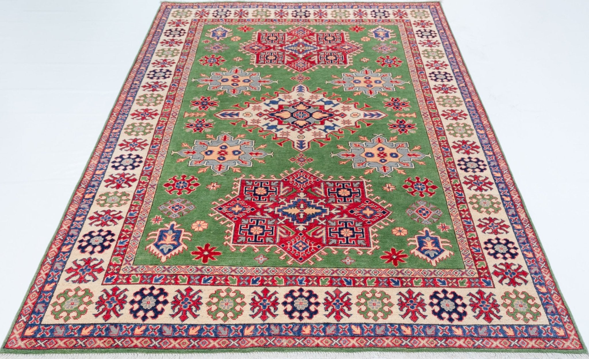 Full view from a low angle of green & red Kazak-inspired wool rug 29641.
