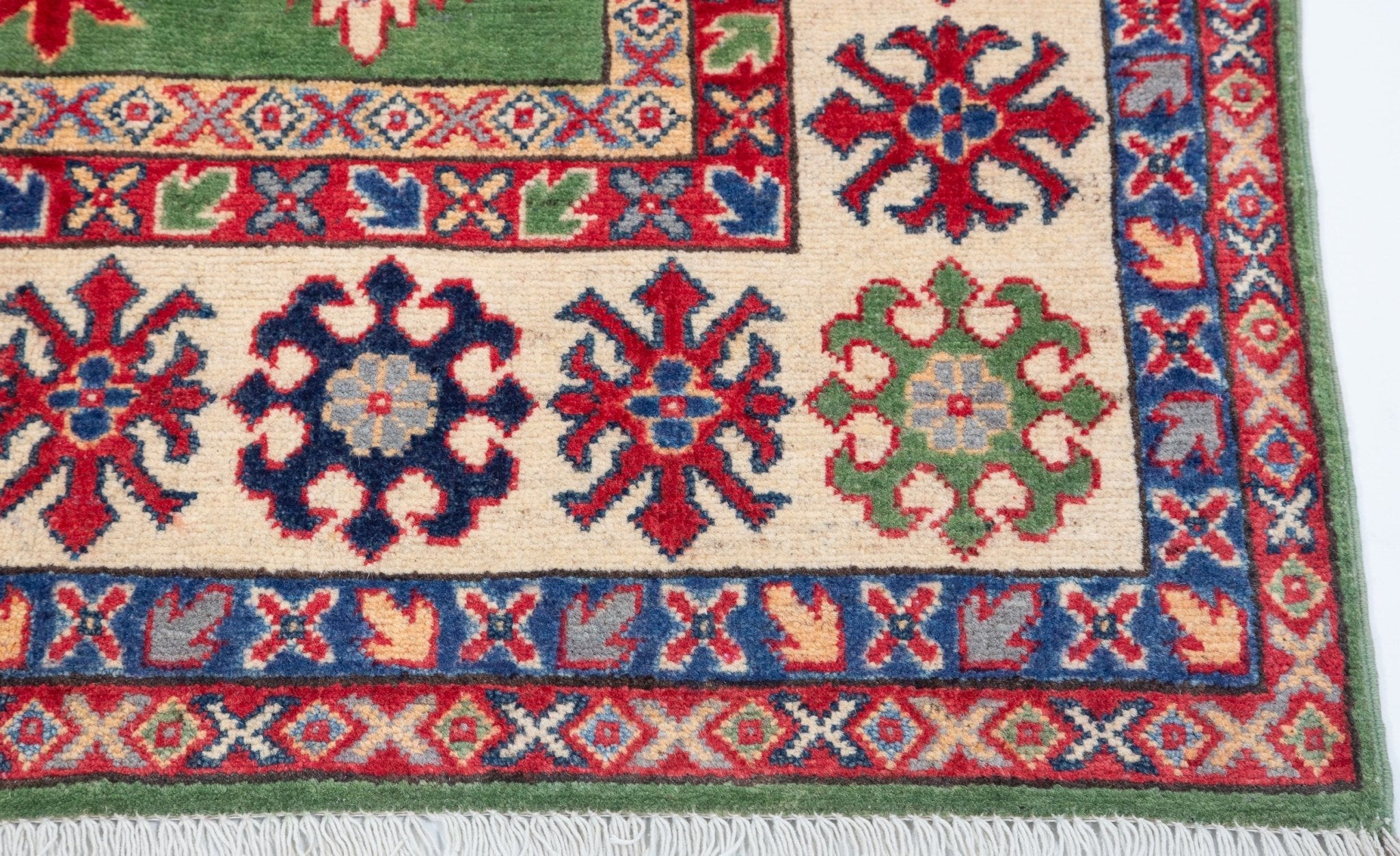 Border and edge detail of green & red Kazak-inspired wool rug 29641.