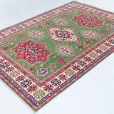 Full view at an angle of green & red Kazak-inspired wool rug 29641.