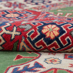 Folded edge and wool pile of green & red Kazak-inspired wool rug 29641.