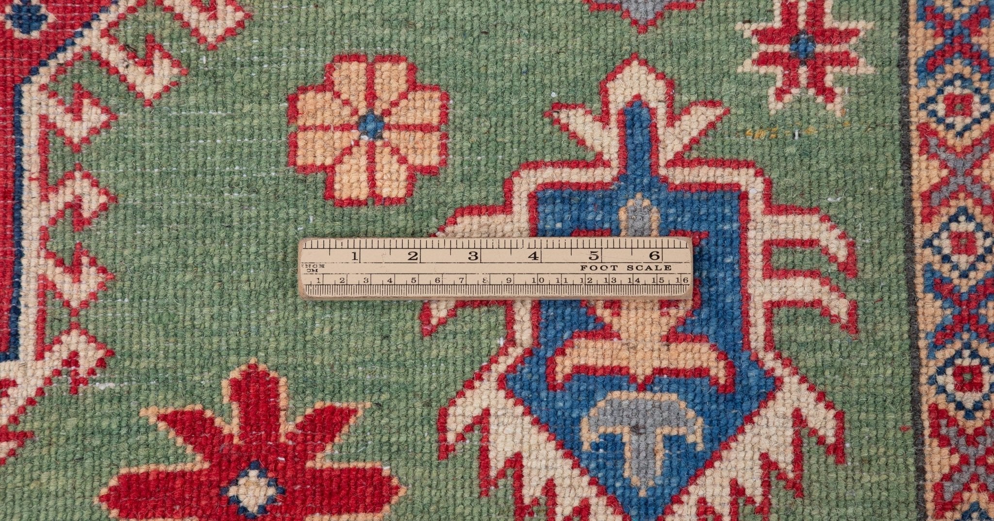 Wool pile close-up of green & red Kazak-inspired wool rug 29641.