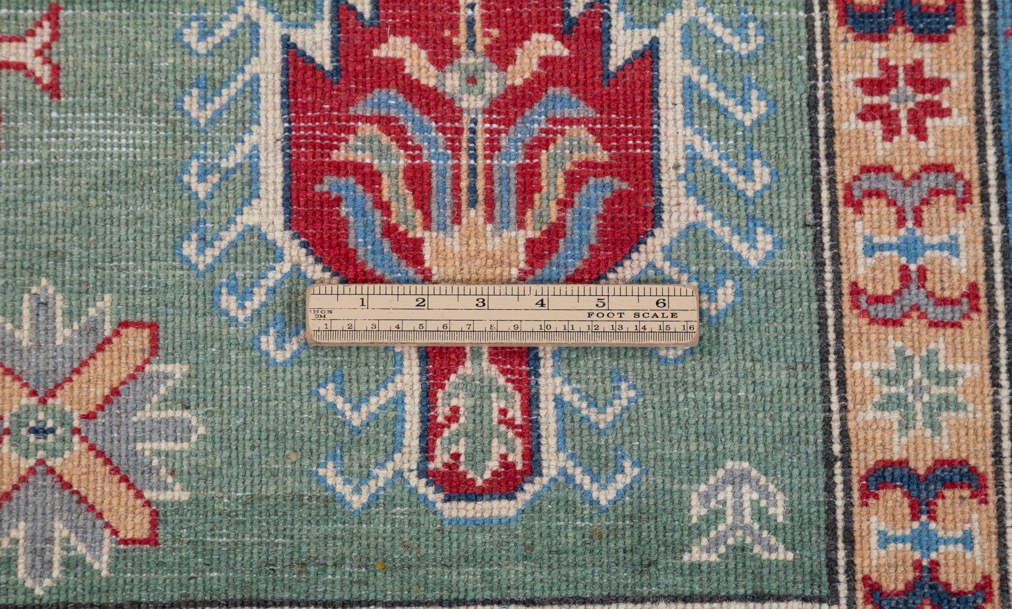 Wool pile close-up of green & ivory Kazak-inspired wool rug 29640.
