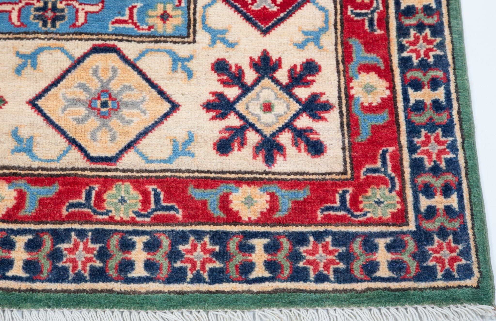 Border and edge detail of green & ivory Kazak-inspired wool rug 29640.