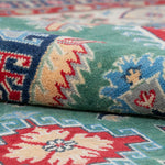 Folded edge and wool pile of green & ivory Kazak-inspired wool rug 29640.