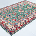 Full view at an angle of green & ivory Kazak-inspired wool rug 29640.