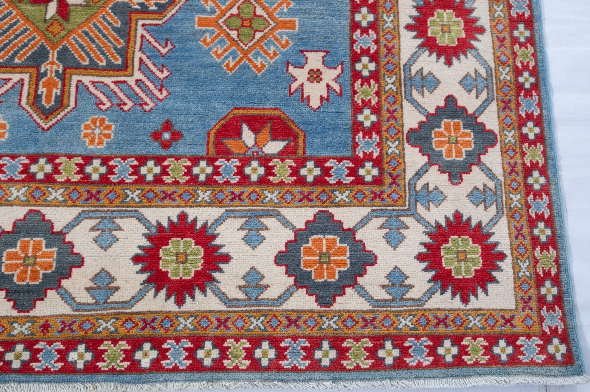 Border and edge detail of blue & red Kazak-inspired wool rug 24986.
