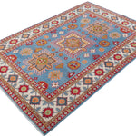 Full view at an angle of blue & red Kazak-inspired wool rug 24986.