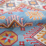 Folded edge and wool pile of blue & red Kazak-inspired wool rug 24986.