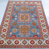 Full view from a low angle of blue & red Kazak-inspired wool rug 24986.