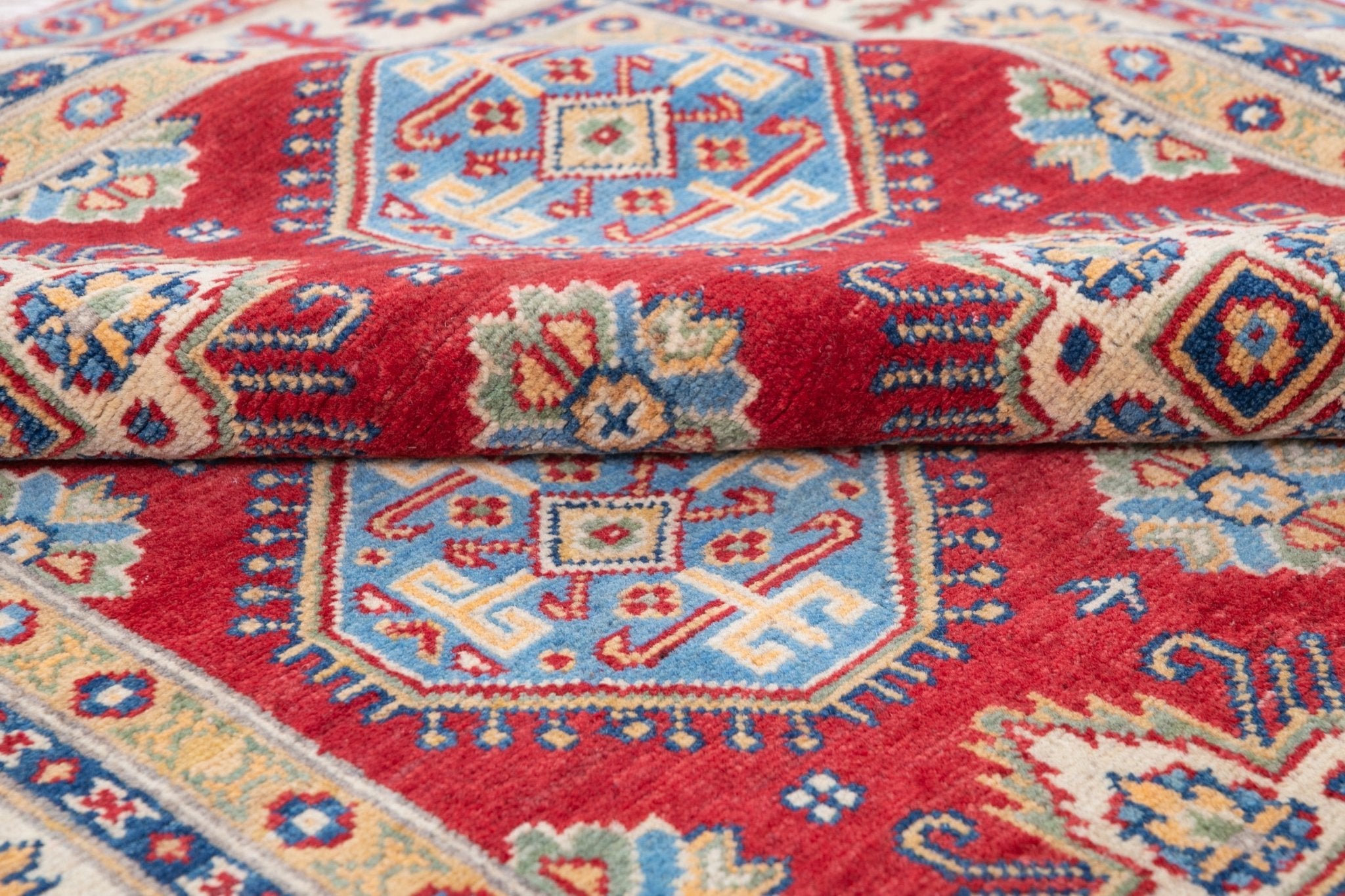 Folded edge and wool pile of red & blue Kazak-inspired wool rug 21988.