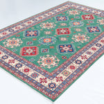 Full view at an angle of green & blue Kazak-inspired wool rug 29639.