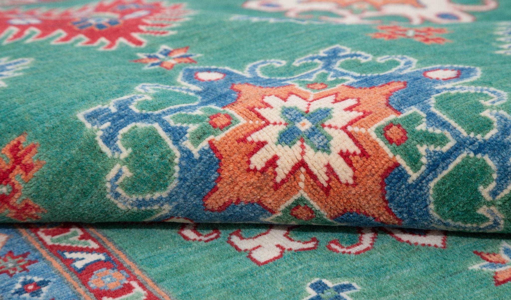 Folded edge and wool pile of green & blue Kazak-inspired wool rug 29639.