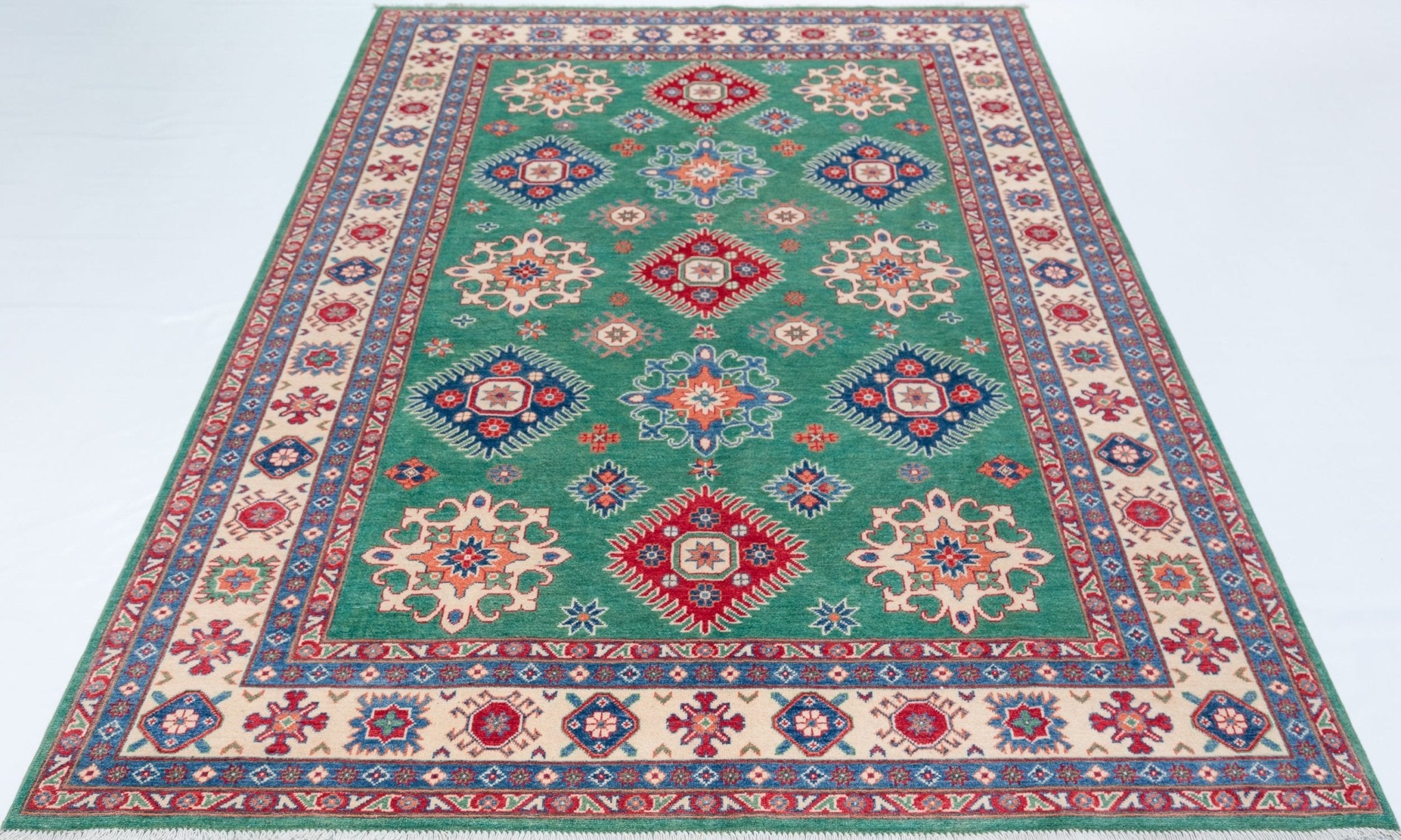 Full view from a low angle of green & blue Kazak-inspired wool rug 29639.