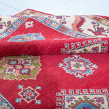 Folded edge and wool pile of red & blue Kazak-inspired wool rug 24995.